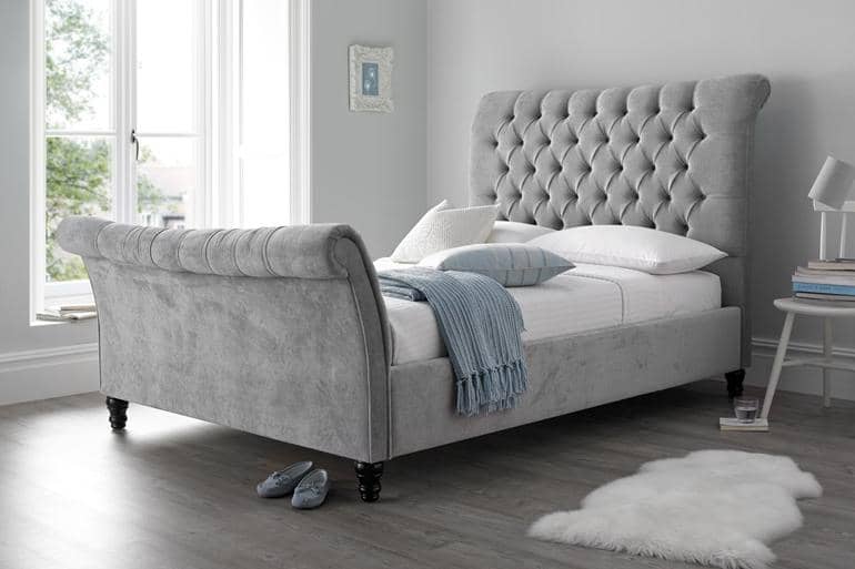 Elegant grey sleigh bed with buttoned back headboard